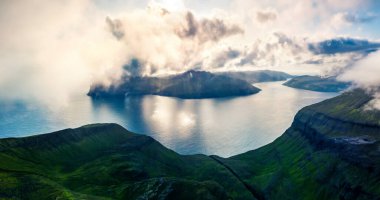 Uçan İHA 'nın görüntüsü. Popüler turizm merkezi Sornfelli 'nin dramatik sabah manzarası. Streymoy Adası 'nın sisli yaz sahnesi. Atlantik Okyanusu 'nun hava sahili, Faroe Adaları, Danimarka, Avrupa.