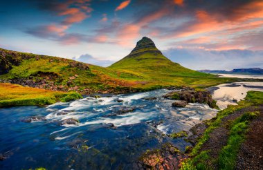 Ünlü Kirkjufellsfoss Şelalesi ve Kirkjufell Dağı 'nda yaz günbatımı. Snaefellsnes yarımadasında renkli bir akşam sahnesi, İzlanda, Avrupa. İşlenmiş fotoğraf sonrası sanatsal stil.