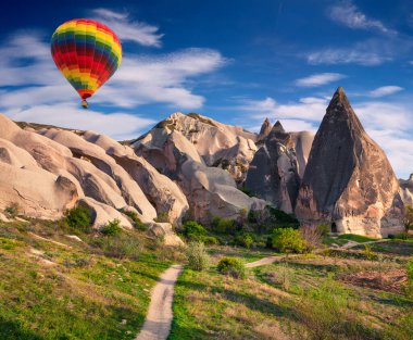 Sabahın erken saatlerinde Cappadocia 'da balonlarla uçmak. Kırmızı Gül Vadisi, Goreme Köyü, Türkiye, Asya 'da renkli gündoğumu. İşlenmiş fotoğraf sonrası sanatsal stil.