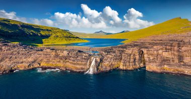 Uçan İHA 'nın görüntüsü. Doğrudan okyanusa düşen Bosdalafossur şelalesinin panoramik sabah manzarası. Sorvagsvatn Gölü, Vagar, Faroe Adaları, Danimarka, Avrupa.