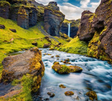 Kvernufoss Watterfall 'un muhteşem öğleden sonra manzarası. Avrupa, İzlanda 'daki saf su nehrinin renkli yaz manzarası. Doğa konseptinin güzelliği.