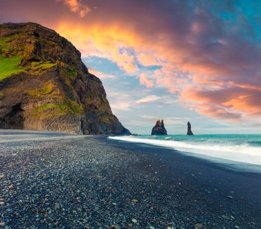 Atlantik Okyanusu 'ndaki Reynisdrangar kayalıklarının muhteşem deniz manzarası. Güney İzlanda 'da, Vic Köyü' nün Avrupa 'da renkli bir yaz günbatımı. İşlenmiş fotoğraf sonrası sanatsal stil.
