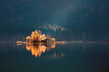 Eibsee Gölü 'nün muhteşem sonbahar sahnesi. Zugspitze zirvesinin, Bavyera 'nın, Almanya' nın ve Avrupa 'nın dibinde parlayan ilk güneş ışığı manzarası inanılmaz. Doğa konseptinin güzelliği.