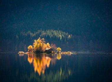 Eibsee Gölü 'nün muhteşem sonbahar sahnesi. Zugspitze zirvesinin, Bavyera 'nın, Almanya' nın ve Avrupa 'nın dibinde parlayan ilk güneş ışığı manzarası inanılmaz. Doğa konseptinin güzelliği.