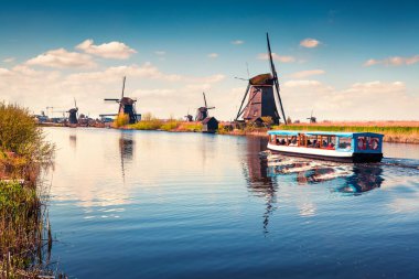 Hollanda 'daki Kinderdijk Müzesi' ndeki ünlü zihin değirmenleri. Kırsal kesimde güneşli bir bahar sabahı. Hollanda, Avrupa 'da renkli bir açık hava sahnesi. UNESCO Dünya Mirası Alanı. İşlenmiş fotoğraf sonrası sanatsal stil.