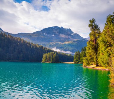 Silvaplana gölünde güneşli bir yaz sabahı. İsviçre Alpleri, Sondrio Bölgesi Lombardiya Bölgesi, İtalya, Avrupa 'da harika bir açık hava sahnesi. İşlenmiş fotoğraf sonrası sanatsal stil.