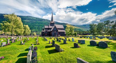 Lom Stavkyrkje (Lom Stavkyrkje) kilisesinin çekici yaz manzarası. Norveç kırsalının güneşli sabah manzarası, Lom belediyesinin idari merkezi - Fossbergom, Norveç, Avrupa.