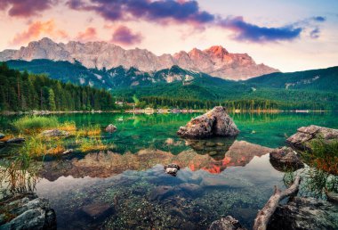 Arka planda Zugspitze sıradağları olan Eibsee Gölü 'nün renkli sabah manzarası. Bavyera Alpleri, Almanya, Avrupa 'nın muhteşem yaz manzarası. Doğa konseptinin güzelliği.