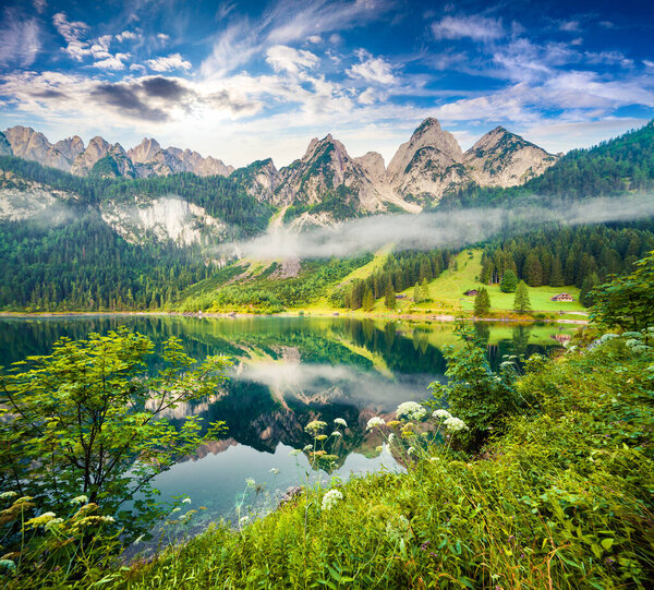 Туманным летним утром на озере Вордерер Госаузи. Красочная сцена на открытом воздухе в австрийских Альпах, курортная зона Зальцкаммергут в долине Госау в Верхней Австрии, Европа. Художественный стиль после обработки фото.