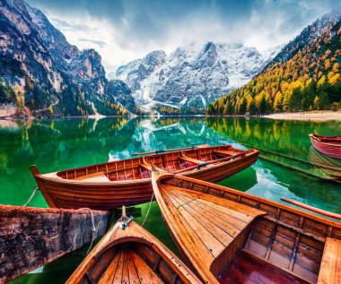 Arka planda Braies Lakeand Seekofel 'deki eğlence tekneleri. İtalyan Alplerinde renkli sonbahar manzarası, Naturpark Fanes-Sennes-Prags, Dolomite, İtalya, Avrupa. İşlenmiş fotoğraf sonrası sanatsal stil.