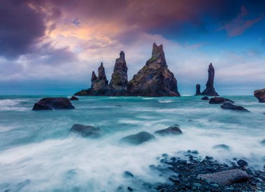 Atlantik Okyanusu 'ndaki Reynisdrangar kayalıklarının dramatik deniz manzarası. Güney İzlanda 'da, Vic Köyü' nün Avrupa 'da renkli bir yaz günbatımı. İşlenmiş fotoğraf sonrası sanatsal stil.