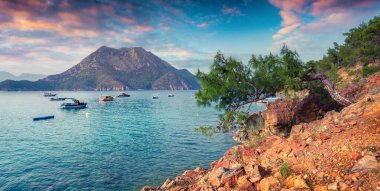 Türkiye 'de resim gibi Akdeniz manzarası. Musa Dağı manzaralı Adrasan Körfezi 'nde renkli bahar günbatımı. İşlenmiş fotoğraf sonrası sanatsal stil.