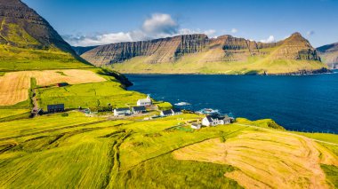 Uçan İHA 'nın görüntüsü. Vidareidi Kirkja 'nın parlak sabah manzarası. Vidoy Adası 'nın panoramik manzarası. Danimarka Krallığı, Avrupa 'nın Faroe Adaları' nın çekici yaz manzarası.