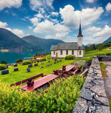 Nes Kilisesi 'nin parlak yaz manzarası, Norveç' in Sogn Og Fjordane ilçesindeki Luster Belediyesi 'ndeki kilise. Lustrafjorden 'in batı kıyısındaki Nes köyünün muhteşem sabah manzarası..
