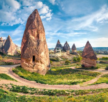 Cappadocia 'nın güneşli bahar manzarası. Nisan ayındaki Kırmızı Gül Vadisi 'nin parlak sabah manzarası. Nevsehir ilçesinin bulunduğu Cavusin köyü, Türkiye, Asya. Seyahat konsepti arka planı.