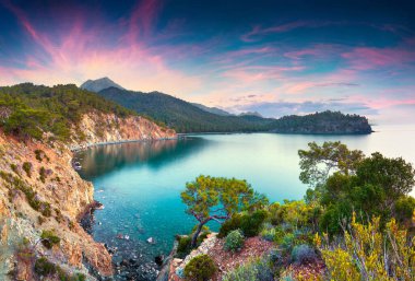 Türkiye 'de renkli Akdeniz manzarası. Antalya ilinin Kemer ilçesine bağlı Tekirova köyü yakınlarındaki küçük bir körfezde bahar gündoğumu. İşlenmiş fotoğraf sonrası sanatsal stil.