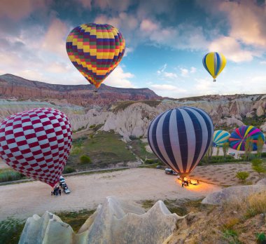 Sabahın erken saatlerinde Cappadocia 'da balonlarla uçmak. Kırmızı Gül Vadisi, Goreme Köyü, Türkiye, Asya 'da renkli gündoğumu. İşlenmiş fotoğraf sonrası sanatsal stil.