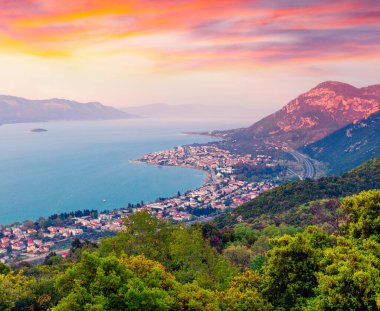 Akşam sisinde Kamena Vourla kasabasının kuş bakışı görüntüsü. Yunanistan, Avrupa 'da renkli bahar şehirleri. Ege Denizi 'nde güzel bir gün batımı. İşlenmiş fotoğraf sonrası sanatsal stil.