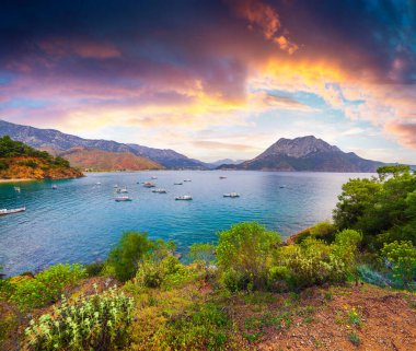 Türkiye 'de resim gibi Akdeniz manzarası. Musa Dağı manzaralı Adrasan Körfezi 'nde renkli bir bahar gündoğumu. Kemer ilçesi, Antalya ili. İşlenmiş fotoğraf sonrası sanatsal stil.