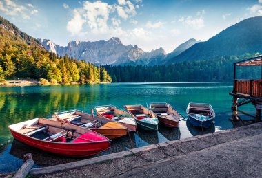 Fusine Gölü 'nde altı tane eğlence teknesi. Julian Alps 'in muhteşem sabah sahnesinde Mangart zirvesi arka planda, Udine ili, İtalya, Avrupa. Seyahat konsepti arka planı.