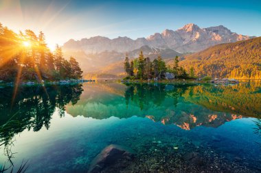 Eibsee Gölü 'nde Zugspitze sıradağlarıyla etkileyici bir yaz gündoğumu. Alman Alpleri, Bavyera, Almanya, Avrupa 'da güneşli bir açık hava sahnesi. Doğa konseptinin güzelliği