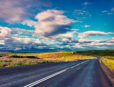 Renkli bulutlu gökyüzü ile boş asfalt yol. İzlanda, Avrupa 'da güzel bir açık hava manzarası. Seyahat kavramı arkaplanı resmi