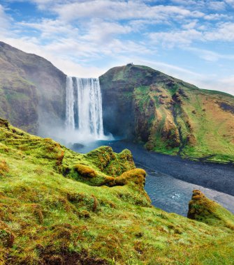 Skogafoss Şelalesi 'nde, Skoga nehrinde sisli bir yaz sabahı. İzlanda, Avrupa 'nın güney kıyısında renkli bir açık hava sahnesi. İşlenmiş fotoğraf sonrası sanatsal stil.