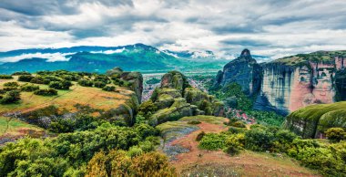 UNESCO Dünya Mirası sitesi Meteora 'nın dramatik bahar manzarası. Kaya sütunlarının üzerine inşa edilmiş Doğu Ortodoks manastırlarının muhteşem sabah manzarası. Kalambaka köyünün yeri, Yunanistan, Avrupa.
