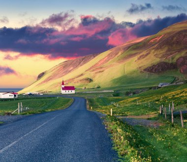 Reyniskirkja Kilisesi, Vik köyü ile dramatik yaz günbatımı. İzlanda, Avrupa 'nın güney kıyısında renkli bir açık hava sahnesi. Seyahat konsepti arka planı