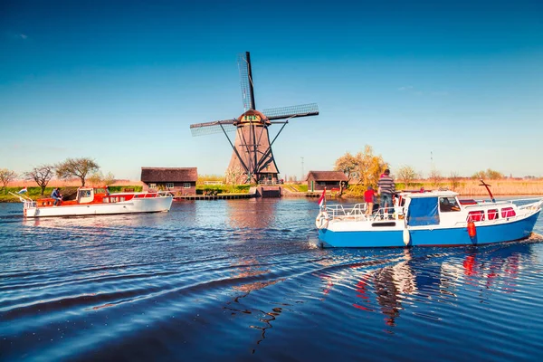 Hollanda 'daki Kinderdijk Müzesi' ndeki ünlü zihin değirmenleri. Kırsal kesimde güneşli bir bahar sabahı. Hollanda, Avrupa 'da renkli bir açık hava sahnesi. UNESCO Dünya Mirası Alanı. İşlenmiş fotoğraf sonrası sanatsal stil.