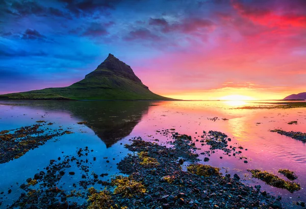 Kirkjufell dağıyla birlikte renkli bir yaz günbatımı. Snaefellsnes yarımadasında dramatik bir sahne. Atlantik Okyanusu, İzlanda, Avrupa 'da gelgit ile birlikte..