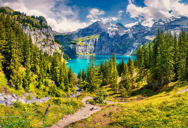 Picturesque summer view of unique Oeschinensee Lake. Sunny morning scene in the Swiss Alps with Bluemlisalp mountain, Kandersteg village location, Switzerland, Europe.