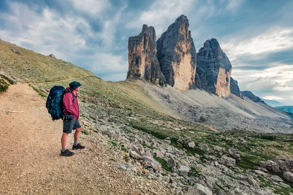 Sırt çantalı, Dolomiti Alpleri 'nin sınırsız ihtişamına hayran. Tre Cime Di Lavaredo 'nun sabah manzarası. Alpler, Güney Tyrol, İtalya ve Avrupa 'nın fantastik yaz sahnesi. 