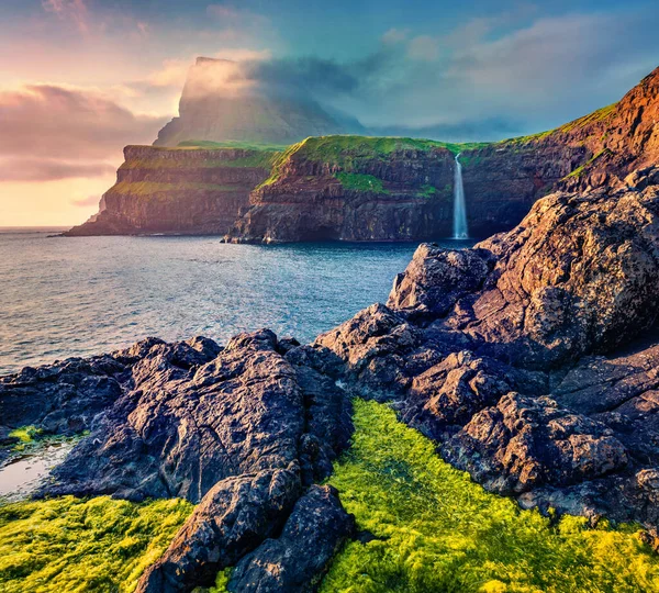 Mulafossur Şelalesi 'nin inanılmaz akşam sahnesi. Vagar Adası, Faroe Adaları, Danimarka Krallığı, Avrupa 'da harika bir yaz günbatımı. Doğa konseptinin güzelliği