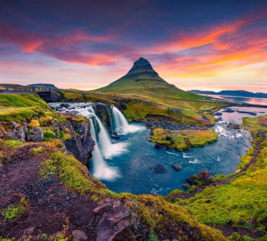 Ünlü Kirkjufellsfoss Şelalesi ve Kirkjufell Dağı 'nda yaz günbatımı. Snaefellsnes yarımadasında dramatik bir akşam sahnesi, İzlanda, Avrupa. İşlenmiş fotoğraf sonrası sanatsal stil.
