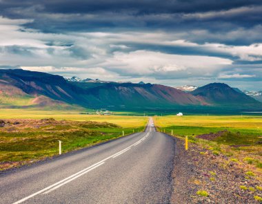 Renkli bulutlu gökyüzü ile boş asfalt yol. İzlanda, Avrupa 'da güzel bir açık hava manzarası. İzlanda, Avrupa 'da güzel bir açık hava manzarası. Seyahat kavramı arkaplanı resmi.