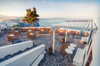 Santorini adasının güneşli sabah manzarası. Yunanistan 'ın ünlü tatil beldesi Fira, Yunanistan ve Avrupa' nın resimli bahar sahnesi. Seyahat konsepti geçmişi. Instagram filtre tonu