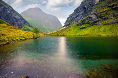 Stavbergvatnet Gölü 'nün yağmurlu yaz manzarası, Hjorundfjorden fijord yakınlarında, Orsta Belediyesi, More og Romsdal İlçesi. Norveç 'in harika sabah manzarası. Doğa konseptinin güzelliği