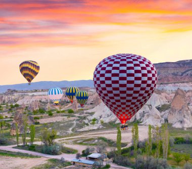 Sabahın erken saatlerinde Cappadocia 'da balonlarla uçmak. Kırmızı Gül Vadisi, Goreme Köyü, Türkiye, Asya 'da renkli gündoğumu. İşlenmiş fotoğraf sonrası sanatsal stil.