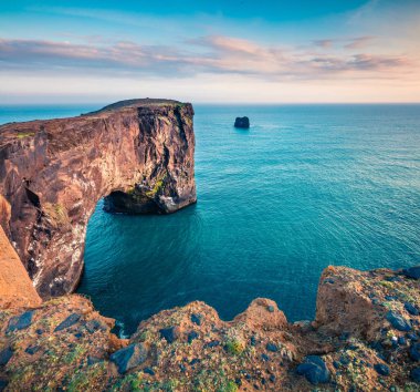 Dyrholaey kemerinin harika akşam manzarası. İzlanda 'nın güney kıyısındaki Dyrholaey Doğa Koruma Alanı' nda dramatik bir yaz günbatımı yaşandı. İşlenmiş fotoğraf sonrası sanatsal stil