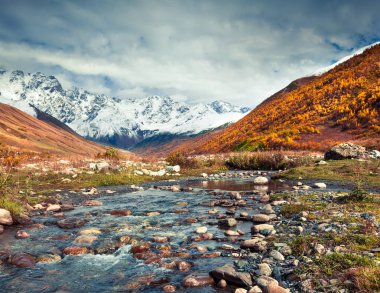 Shkhara Dağı 'nın güney eteklerinde. Ushguli köyünden görüntü. Kafkasya dağlarında renkli bir sonbahar sabahı, Yukarı Svaneti, Gürcistan, Avrupa. İşlenmiş fotoğraf sonrası sanatsal stil.