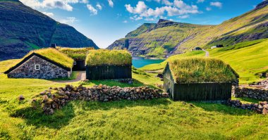 Saksun köyünün panoramik yaz manzaralı tipik otlak evleri ve Saksunar Kirkja, Faroe Adaları. Danimarka, Avrupa 'daki Streymoy Adası' nın güneşli bir sabah manzarası. Seyahat konsepti arka planı