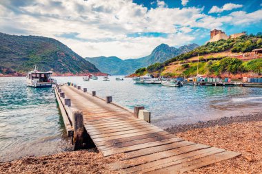 Girolata Limanı 'ndaki eski ahşap iskele. Arabayla gidilemeyen bir yer. Korsika adası, Fransa, Avrupa 'nın güneşli yaz manzarası. Güzel Akdeniz deniz manzarası. Seyahat konsepti arka planı