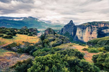 UNESCO Dünya Mirası sitesi Meteora 'da dramatik bir bahar sahnesi. Kaya sütunlarının üzerine inşa edilmiş Doğu Ortodoks manastırlarının muhteşem sabah manzarası. Kalambaka köyünün yeri, Yunanistan, Avrupa.