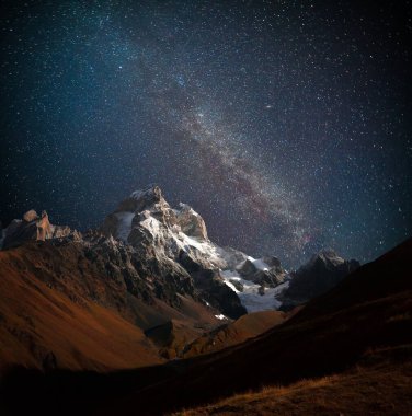 Karanlık yıldızlı gökyüzü ile Ushba Dağı 'nın gece manzarası. Kafkasya dağlarında güzel bir açık hava manzarası, Yukarı Svaneti, Avrupa. 