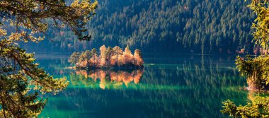 Eibsee Gölü 'nün muhteşem sonbahar manzarası. Zugspitze zirvesinin, Bavyera 'nın, Almanya' nın ve Avrupa 'nın dibindeki küçük adanın güneşli sabah manzarası. Doğa konseptinin güzelliği.