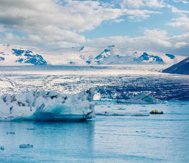 Jokulsarlon 'un buzul gölünde yüzen mavi buzdağlarının görüntüsü. Vatnajokull Ulusal Parkı, Güneydoğu İzlanda, Avrupa 'da tekne gezisi. İşlenmiş fotoğraf sonrası sanatsal stil.