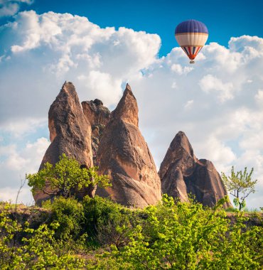 Cappadocia 'da balonlarla uçmak. Kırmızı Gül Vadisi, Goreme Köyü, Türkiye, Asya 'da renkli bir bahar manzarası. İşlenmiş fotoğraf sonrası sanatsal stil.