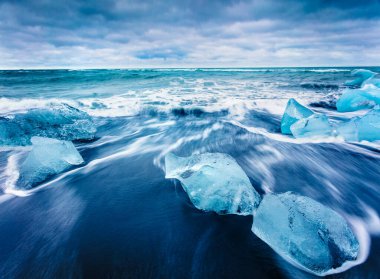 Jokulsarlon sahilindeki dalgalarla yıkanmış buz blokları. Güneydoğu İzlanda, Avrupa 'daki Vatnajokull Ulusal Parkı' nın dramatik yaz sahnesi. Doğa konseptinin güzelliği.