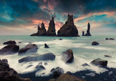 Atlantik Okyanusu 'ndaki Reynisdrangar kayalıklarının dramatik deniz manzarası. Güney İzlanda 'da, Vic Köyü' nün Avrupa 'da renkli bir yaz günbatımı. İşlenmiş fotoğraf sonrası sanatsal stil.